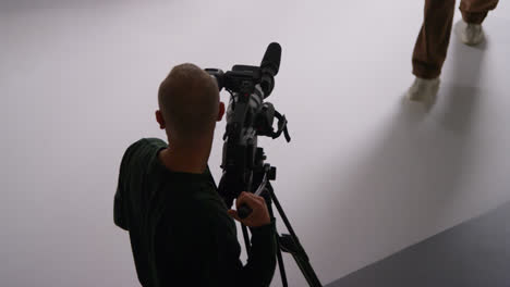 Overhead-Shot-Of-Male-Film-Camera-Operator-Focusing-Cameras-Using-Monitor-Shooting-Movie-Or-Video-In-Studio